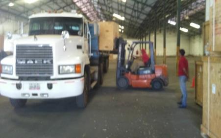 Camión y montacargas durante la carga de materiales en un almacén
