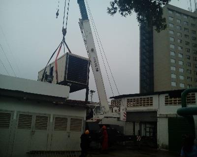 Grúa izando una planta eléctrica junto a las instalaciones del hotel