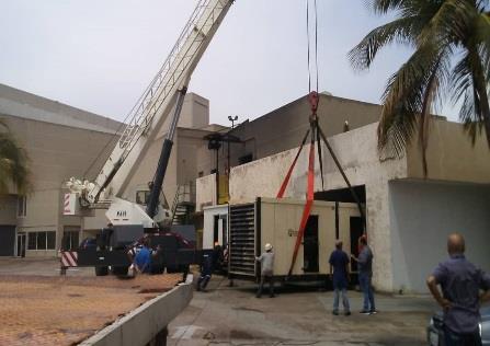 Personal y grúa durante el posicionamiento de una planta eléctrica